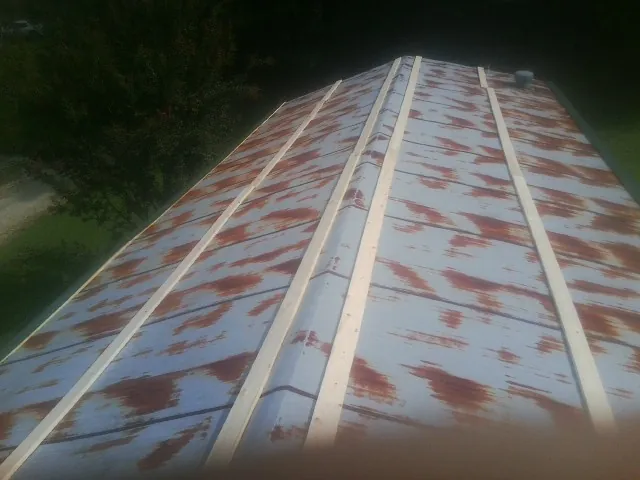 Rusted metal roof panels with new wood purlins before replacement — Storm Damage Roof Repair in Grand Saline by Roofing Brothers