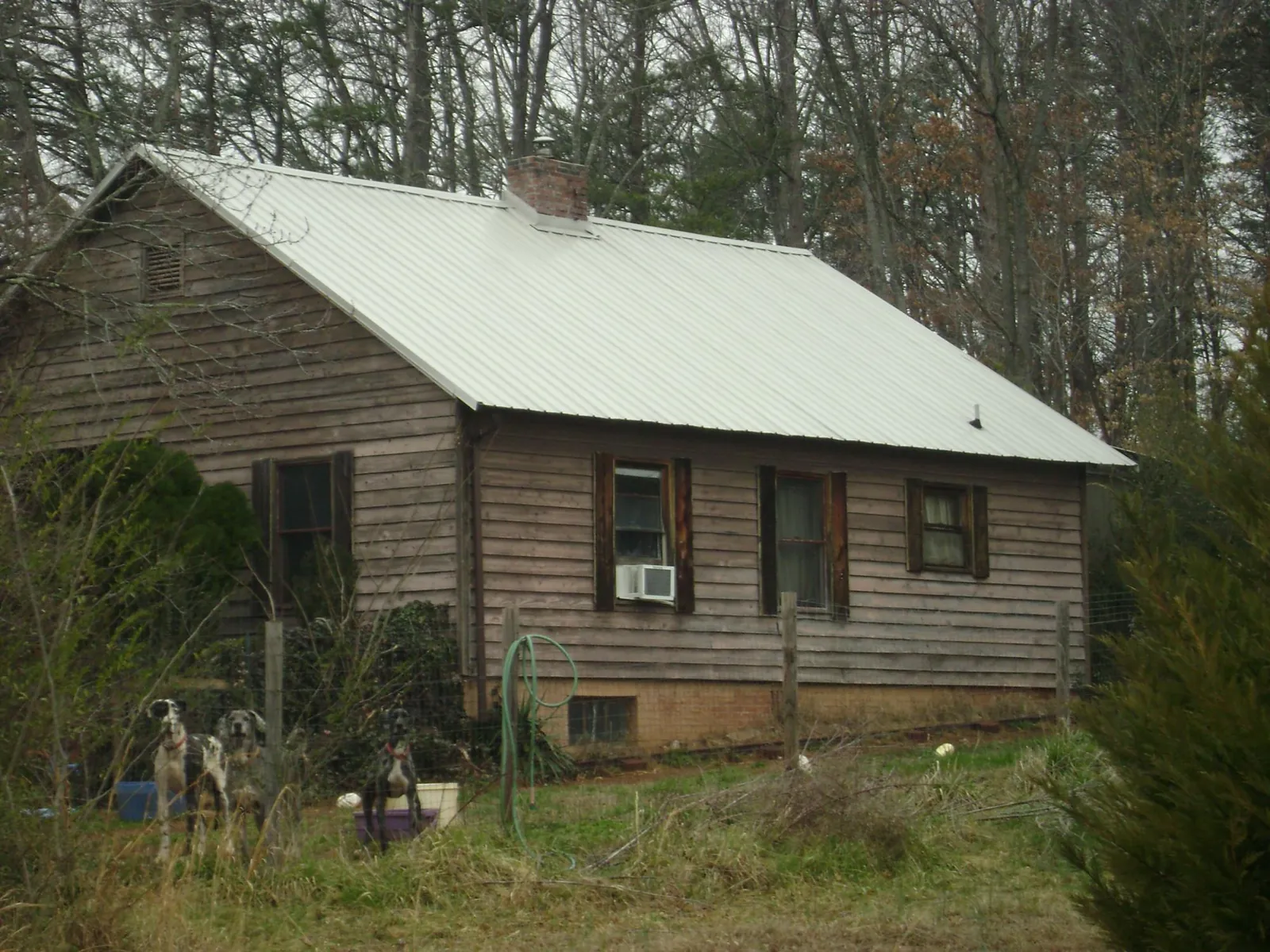 White metal roof on an old wood sided farmhouse, from a Metal Roof Installation job in Grand Saline